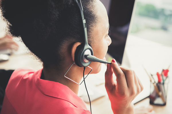 Woman wearing a headset while sitting at her desk.